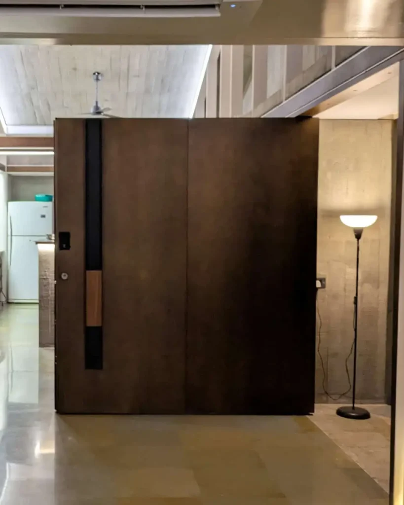 Entrance featuring a fully customized bronze-finished door, natural iroko wood handle, and secure integrated smart access with multi-point locking by Silvelox, created by Metal Fabrik.